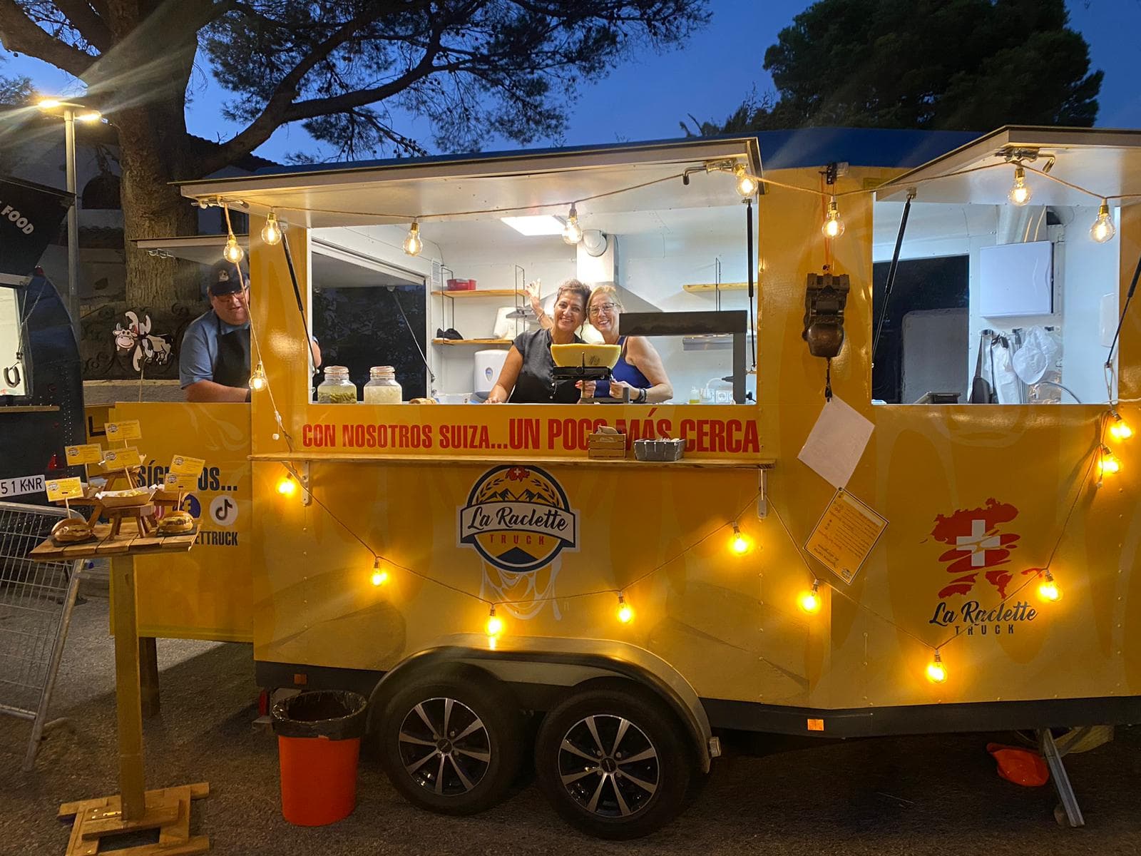 Puesto food truck de La RacletTruck iluminado de noche listo para servir raclette suizo